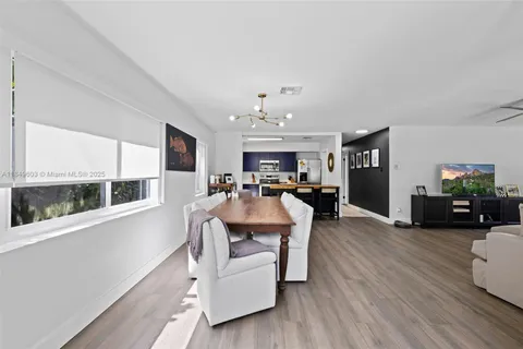 a living room with furniture a flat screen tv and a floor to ceiling window