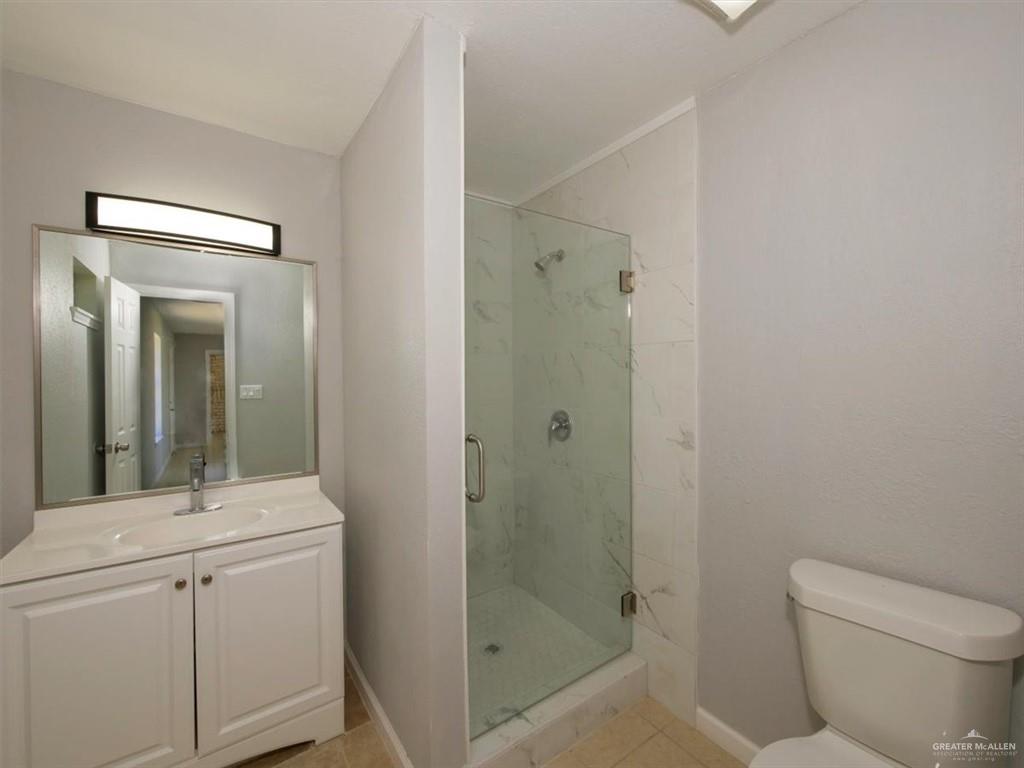4507 West Rogers Road Edinburg, TX 78541 - Photo 11 of 21 a bathroom with a toilet a sink and shower