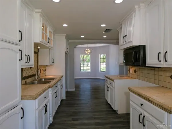 a kitchen with stainless steel appliances kitchen island granite countertop a sink and a stove