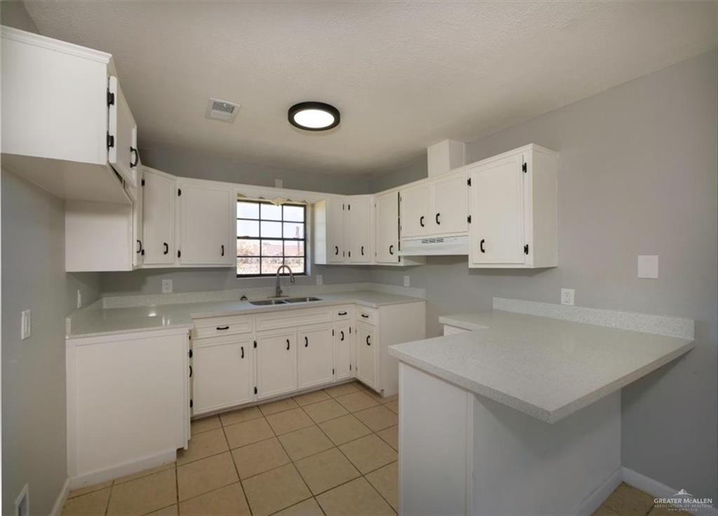 4507 West Rogers Road Edinburg, TX 78541 - Photo 9 of 21 a kitchen with granite countertop white cabinets and white appliances