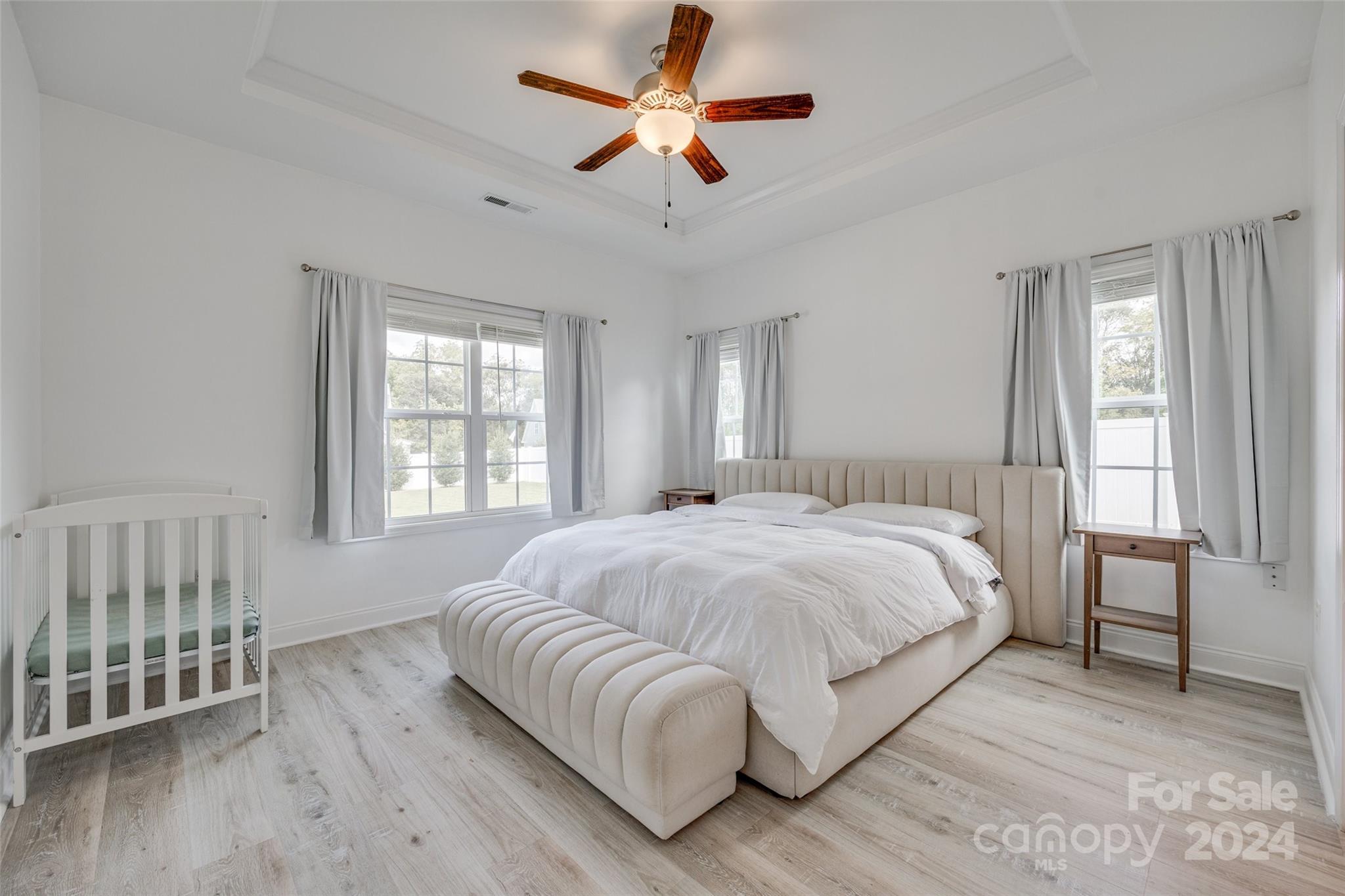 4725 Olive Branch Road Wingate, NC 28174 - Photo 20 of 39 a spacious bedroom with a large bed chandelier and a window