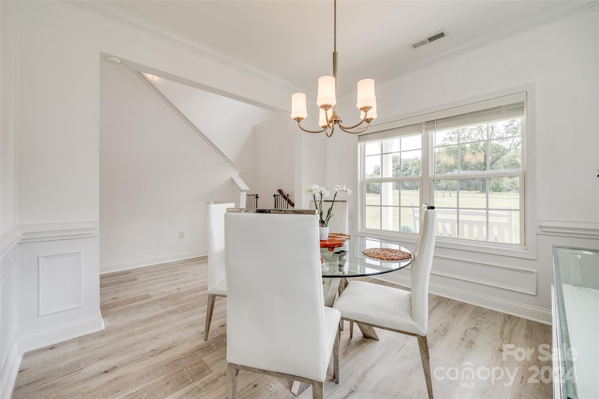4725 Olive Branch Road Wingate, NC 28174 - Photo 7 of 39 a dining room with wooden floor a chandelier a wooden table and chairs