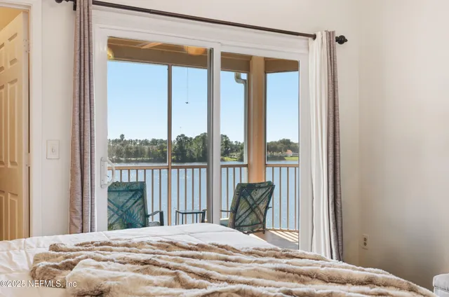 a bedroom with a bed and a large window