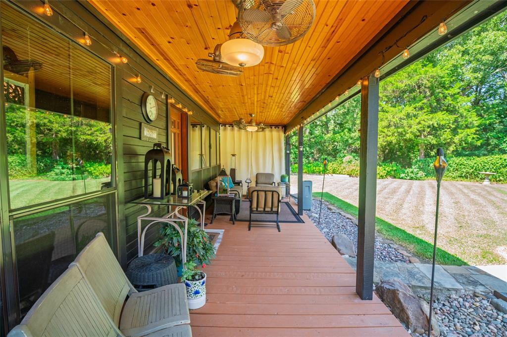 1516 Rancho Road Quinlan, TX 75474 - Photo 27 of 40 a view of a patio with table and chairs potted plants with wooden floor and fence
