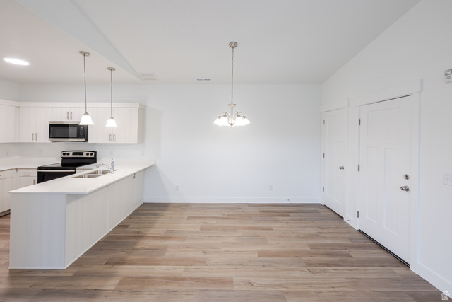 4661 Poplar Way, Unit R304 Mapleton, UT 84664 - Photo 13 of 17 Kitchen featuring white cabinetry, stainless steel appliances, light wood-type flooring, a peninsula, and suspended lighting