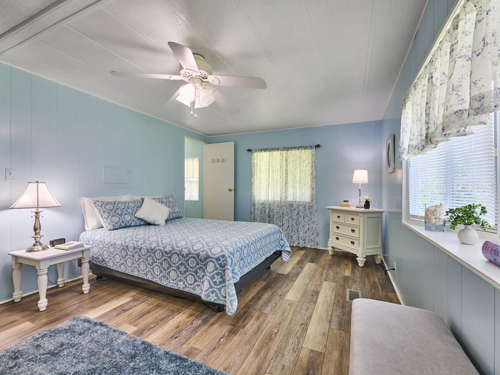 6977 Southeast Delegate Street Hobe Sound, FL 33455 - Photo 28 of 60 a bedroom with a bed and a chandelier