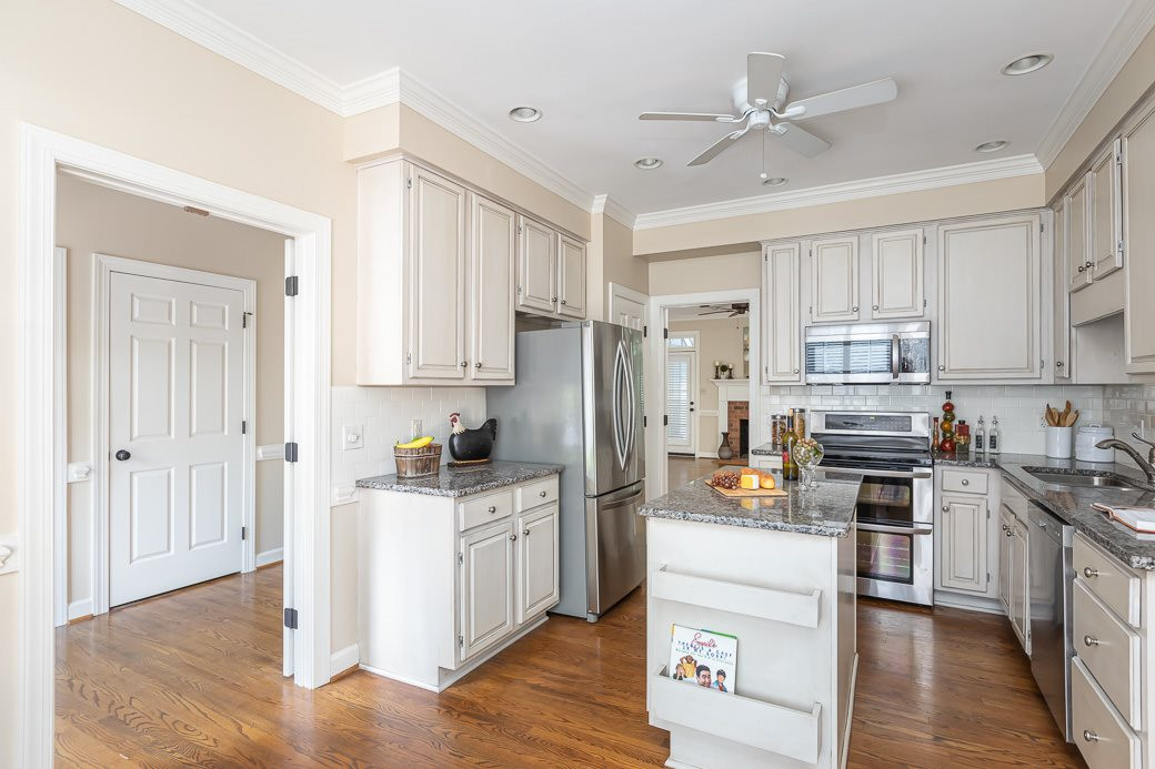 6120 Friars Walk Place Raleigh, NC 27609 - Photo 3 of 21 The open kitchen offers GRANITE counters, work island, TILE backsplash, STAINLESS STEEL APPLIANCES, and HARDWOOD floors. KITCHEN
