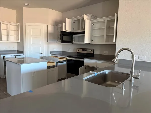 a kitchen that has a sink and a stove in it