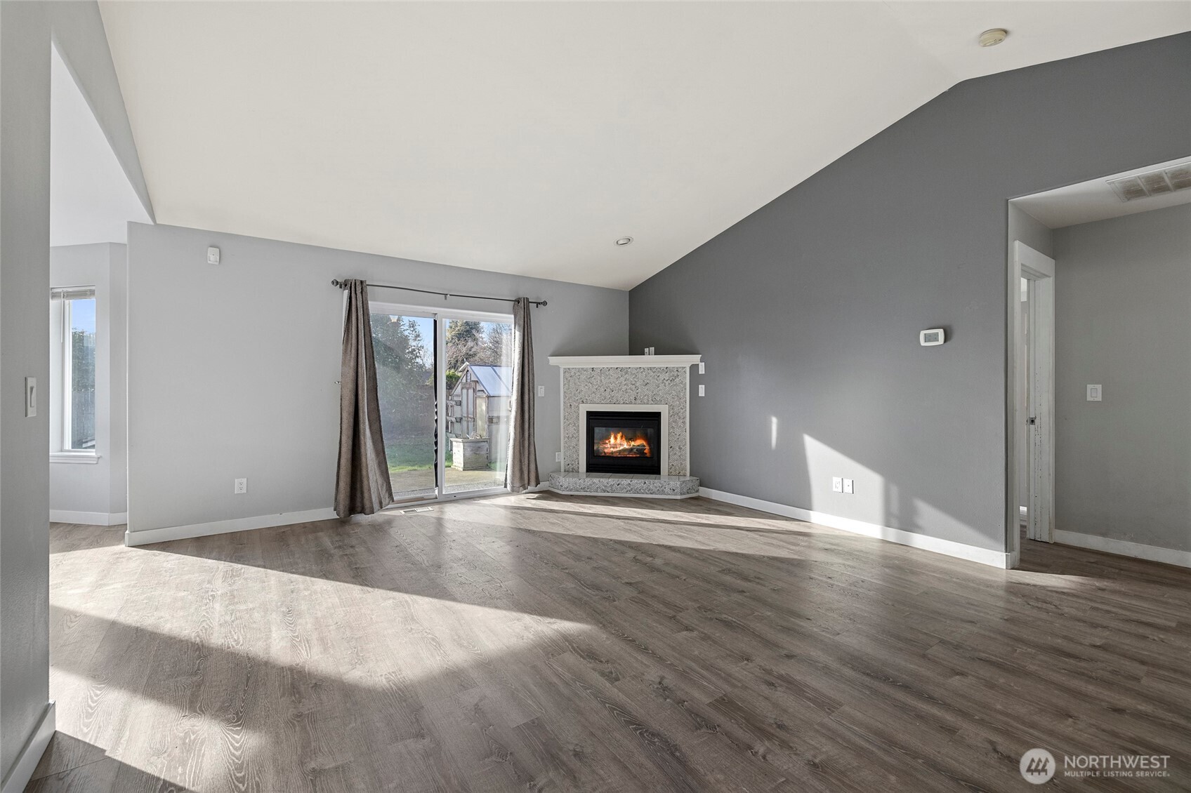 827 John Liner Road Sedro-Woolley, WA 98284 - Photo 3 of 36 a view of an empty room with wooden floor fireplace and a window