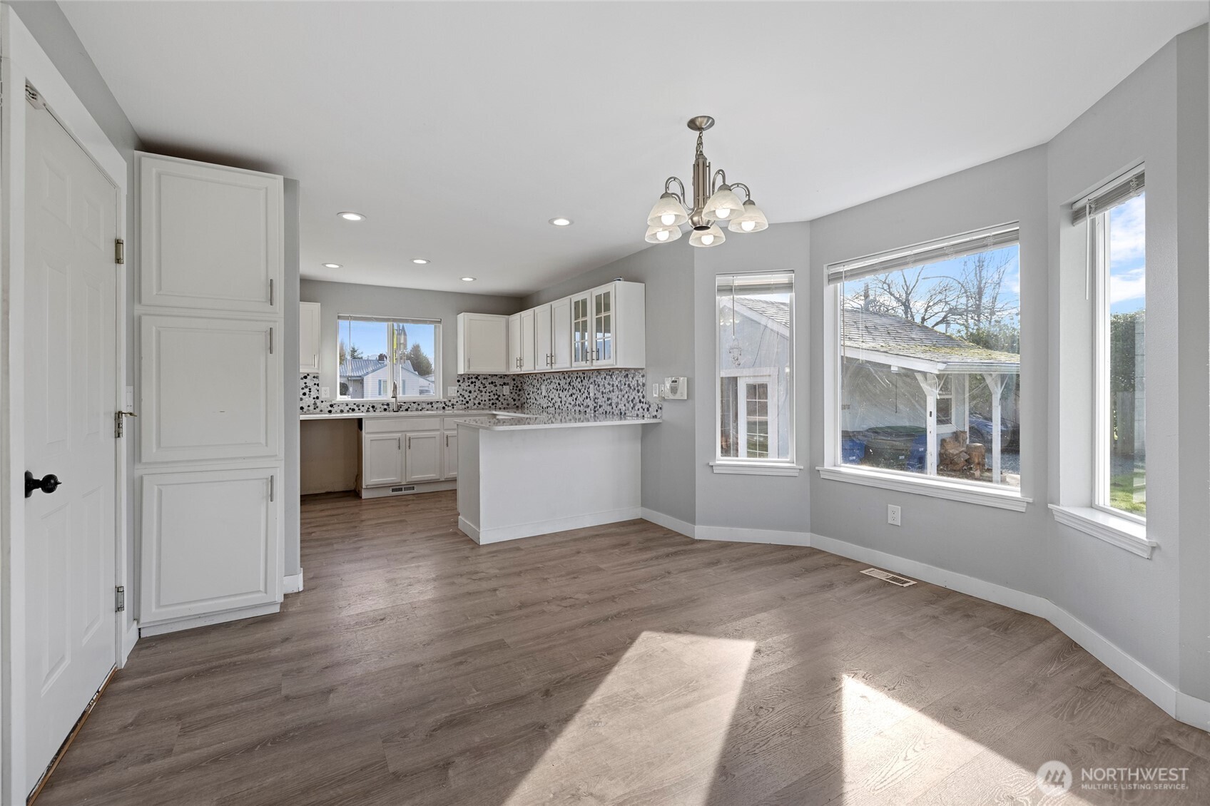 827 John Liner Road Sedro-Woolley, WA 98284 - Photo 8 of 36 a large white kitchen with kitchen island a chandelier appliances and cabinets