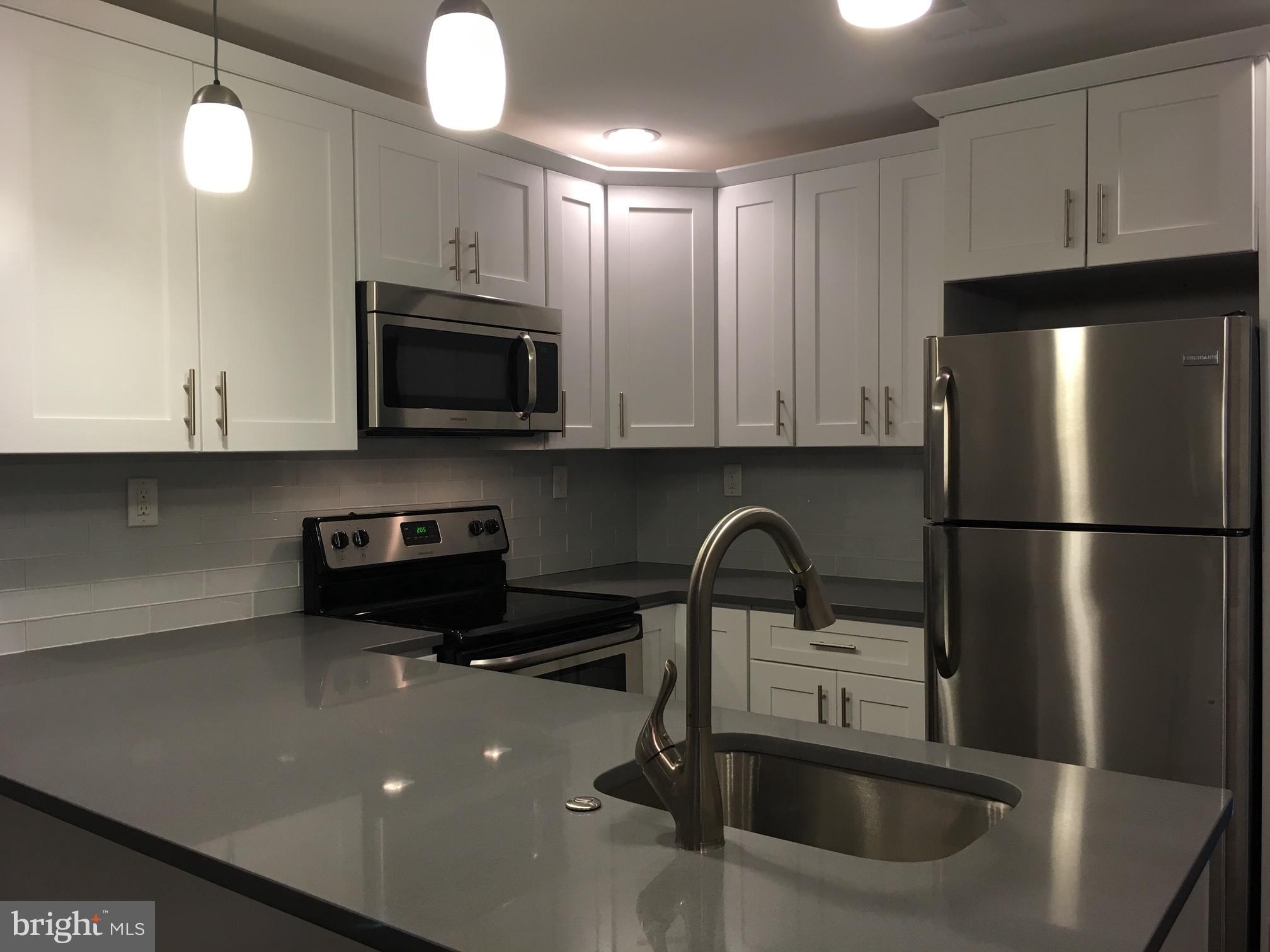 a kitchen with a sink a microwave and refrigerator