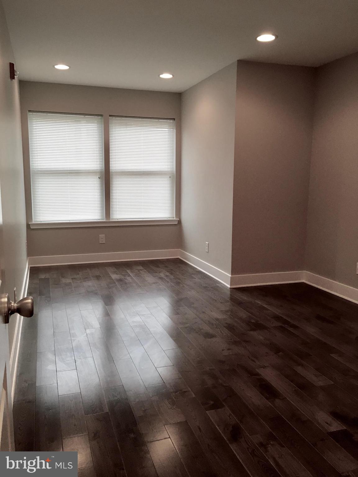 2341 West Thompson Street, Unit C Philadelphia, PA 19121 - Photo 12 of 13 an empty room with wooden floor and windows