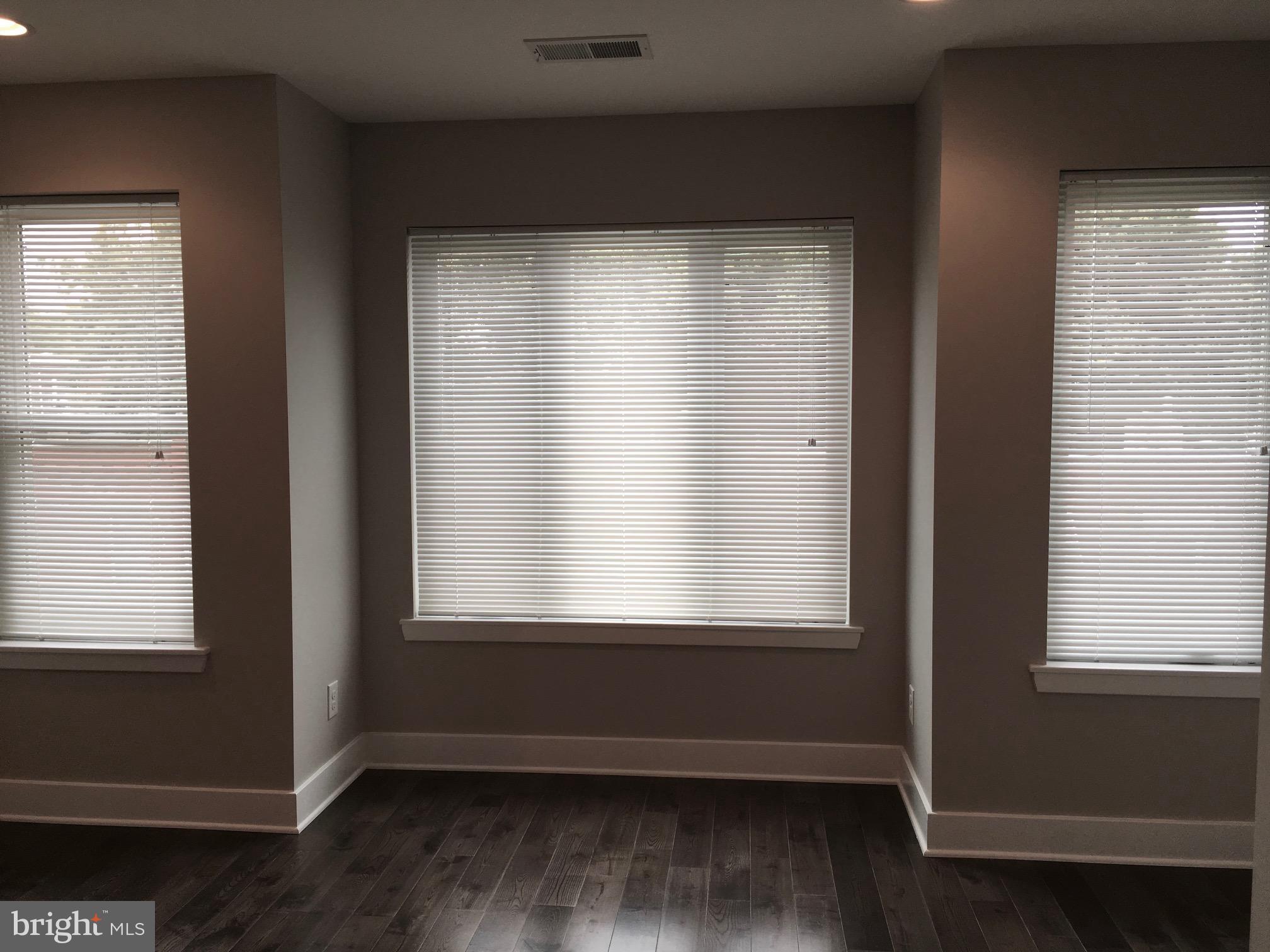 2341 West Thompson Street, Unit C Philadelphia, PA 19121 - Photo 4 of 13 a view of an empty room with wooden floor and a window