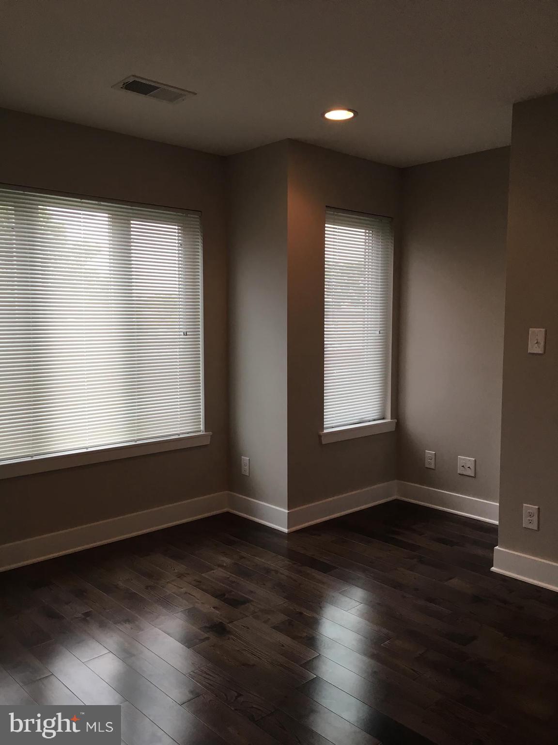 2341 West Thompson Street, Unit C Philadelphia, PA 19121 - Photo 5 of 13 a view of an empty room with wooden floor and a window