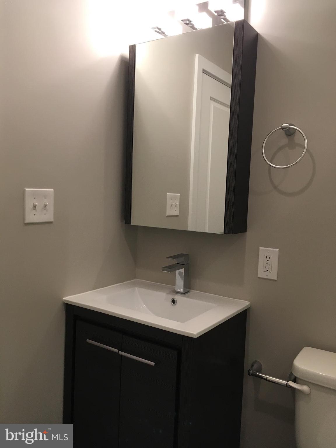 2341 West Thompson Street, Unit C Philadelphia, PA 19121 - Photo 8 of 13 a bathroom with a sink vanity and mirror