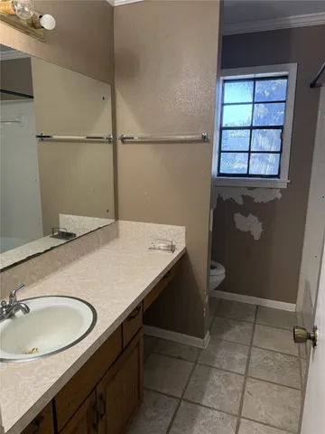 a bathroom with a granite countertop sink a toilet and a mirror