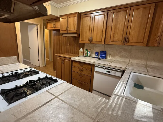 a kitchen with stainless steel appliances a stove a sink and cabinets