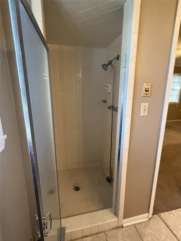 a bathroom with a shower and a glass door