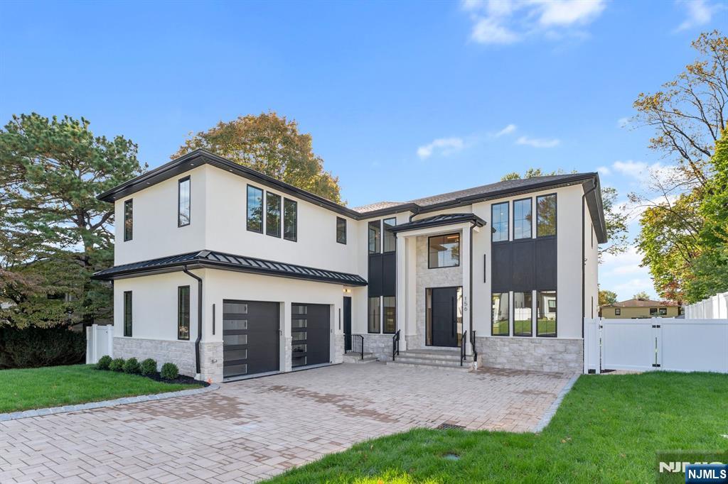 156 Stuart Street Paramus, NJ 07652 - Photo 2 of 47 a front view of a house with a garden and yard