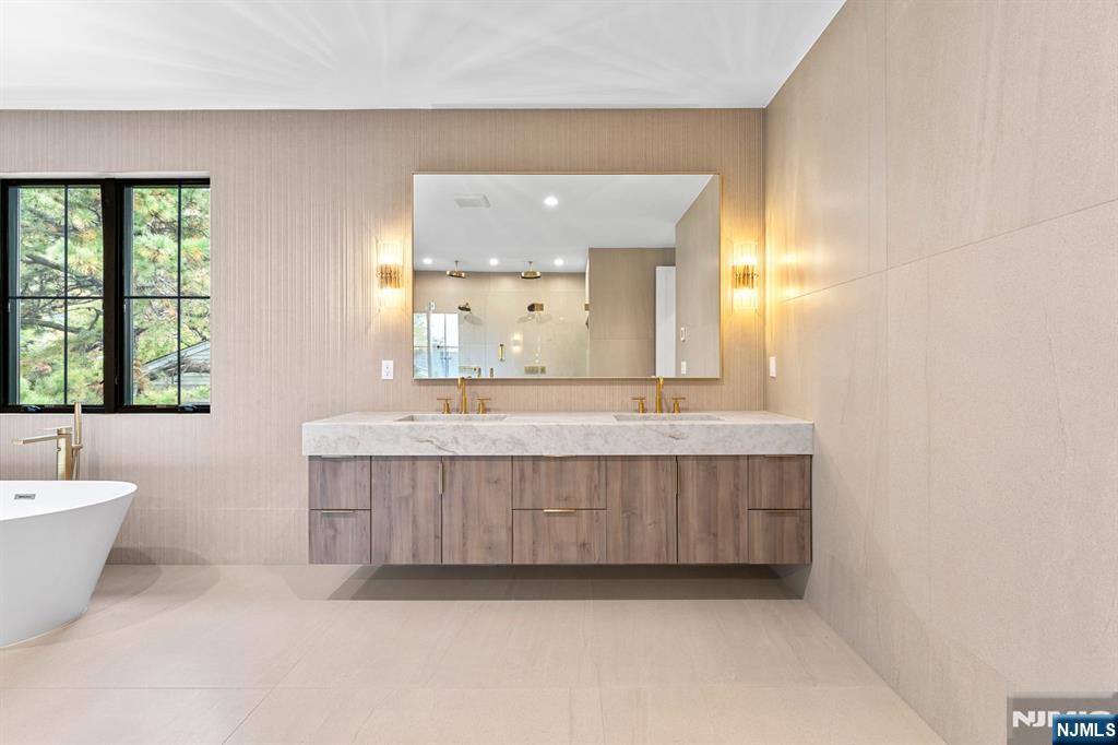 156 Stuart Street Paramus, NJ 07652 - Photo 26 of 47 a bathroom with a bathtub a mirror a sink and window