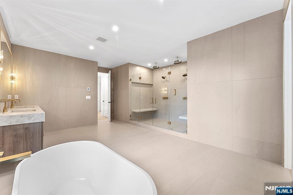 156 Stuart Street Paramus, NJ 07652 - Photo 28 of 47 a bathroom with a bathtub shower sink and mirror