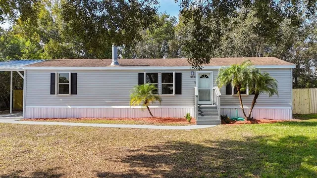 a view of a house with backyard and tree