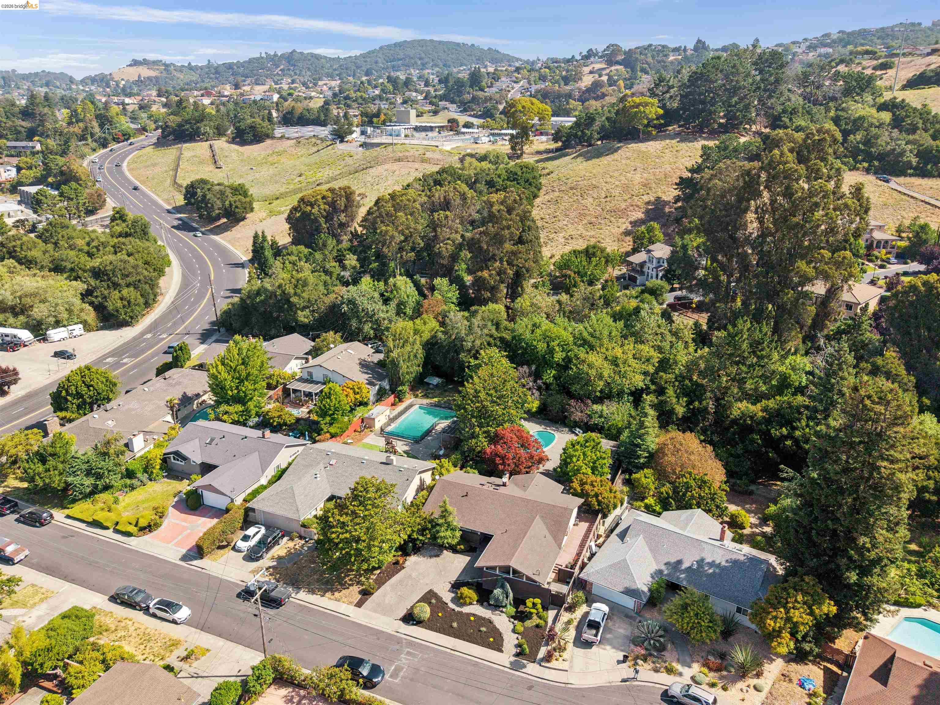 7 Jo Lin Court El Sobrante, CA 94803 - Photo 5 of 99 Residential neighborhood featuring a curvilinear road, mature trees, and a distant hillside backdrop