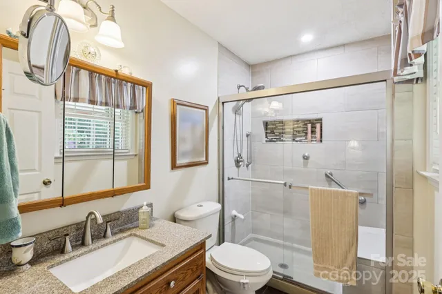 a bathroom with a granite countertop sink toilet and shower