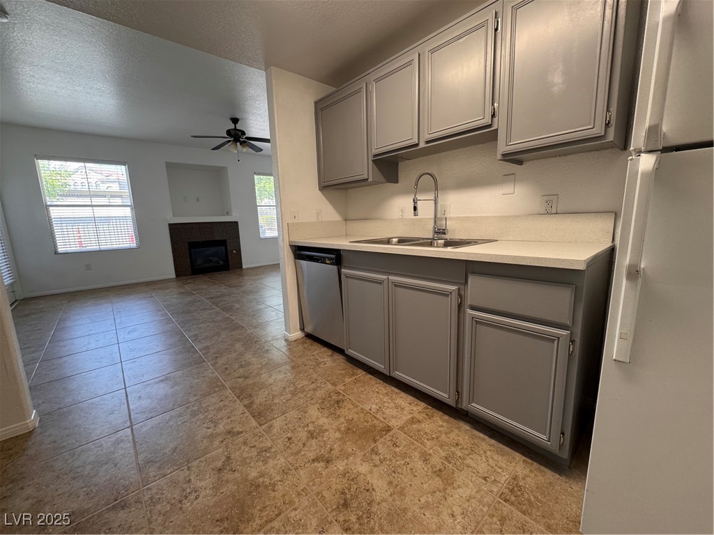 9975 Peace Way, Unit 1140 Las Vegas, NV 89147 - Photo 4 of 23 Kitchen featuring a ceiling fan, dishwashing machine, a sink, and gray cabinets