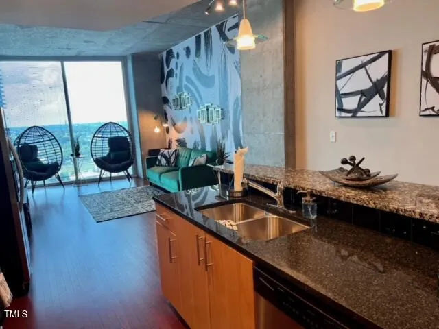 a kitchen with stainless steel appliances granite countertop a sink a counter space and a window