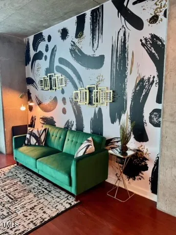 a living room with furniture and a painting on the wall