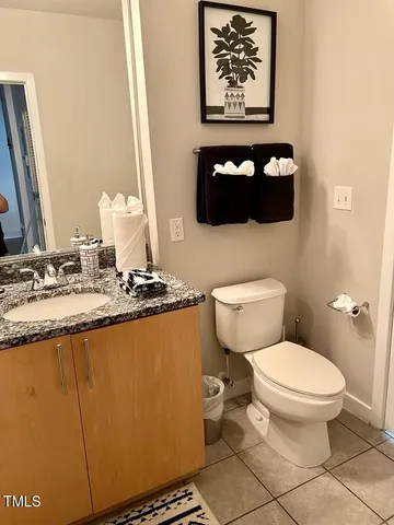a bathroom with a granite countertop toilet and a sink
