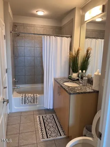 a bathroom with a granite countertop sink a toilet and shower
