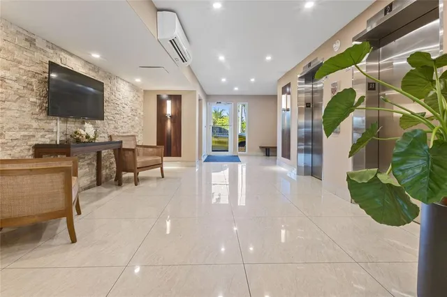 a lobby with furniture and a flat screen tv