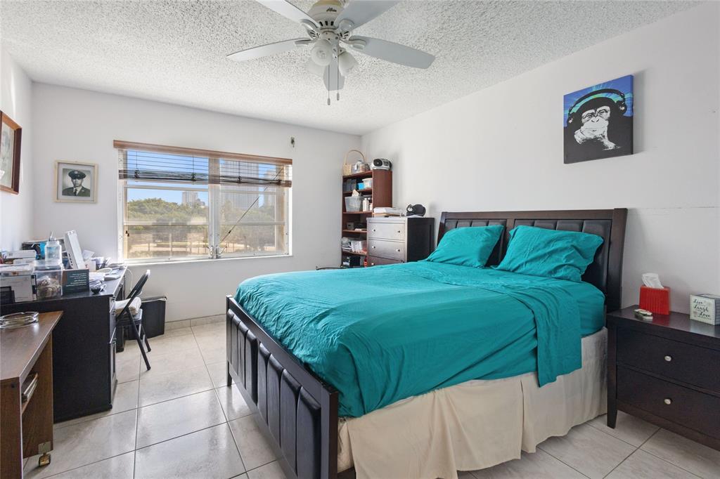 200 Diplomat Parkway, Unit 520 Hallandale Beach, FL 33009 - Photo 10 of 17 a bedroom with a bed and a table in it