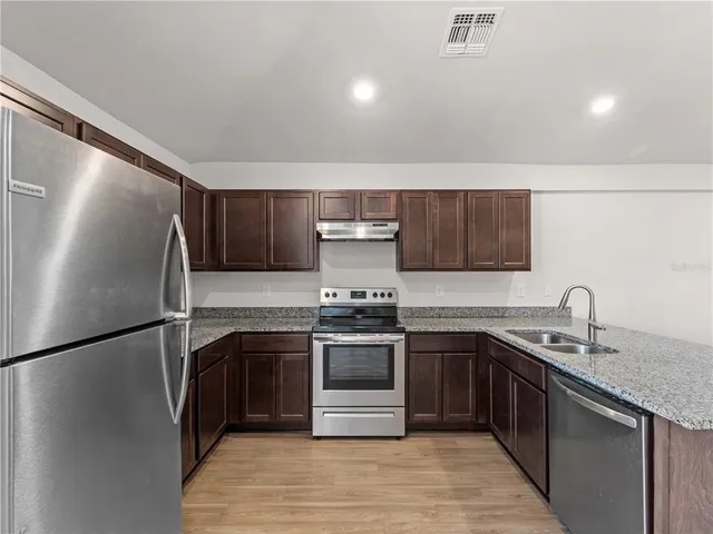 a view of a room with wooden floor fan and windows