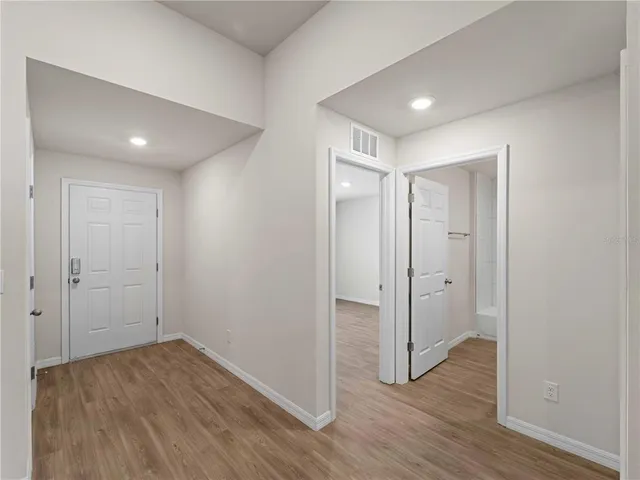 a view of a hallway with wooden floor and closet