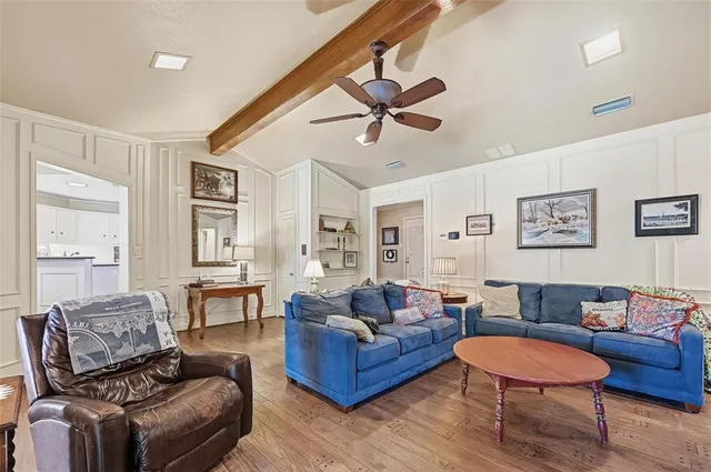 a living room with furniture a ceiling fan and a window
