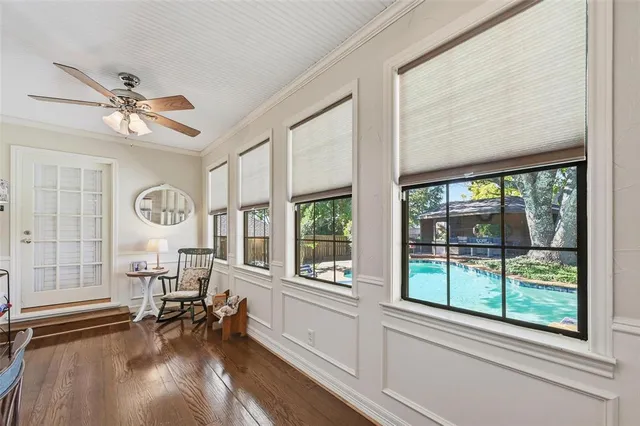 a view of a livingroom with furniture a ceiling fan and a large window