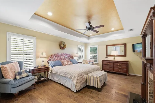 a bedroom with a large bed couch and windows