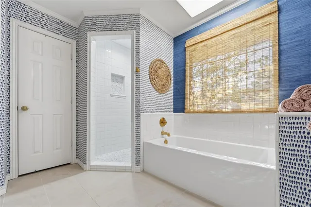 a bathroom with a tub a window and a shower