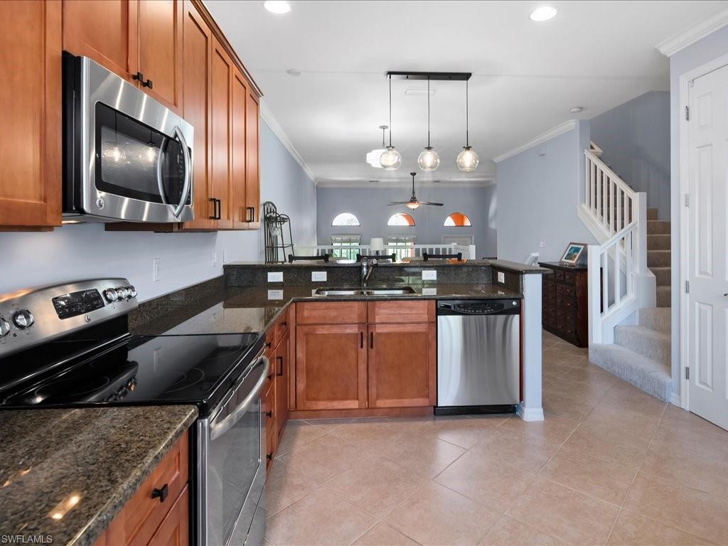 8985 Cambria Circle, Unit 215 Naples, FL 34113 - Photo 15 of 36 a kitchen with stainless steel appliances granite countertop a sink a stove and a microwave