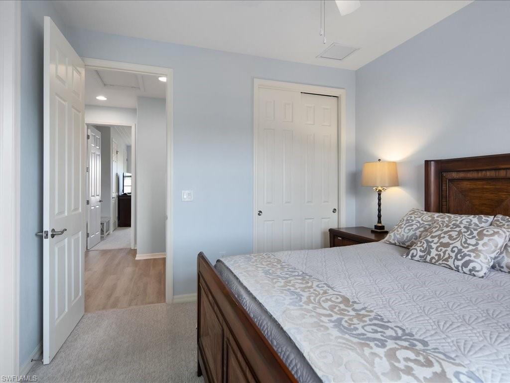 8985 Cambria Circle, Unit 215 Naples, FL 34113 - Photo 21 of 36 a bedroom with a bed and a lamp