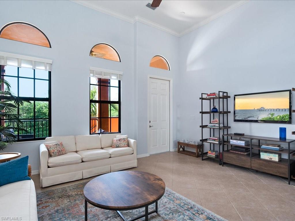 8985 Cambria Circle, Unit 215 Naples, FL 34113 - Photo 7 of 36 a living room with furniture a window and a chandelier