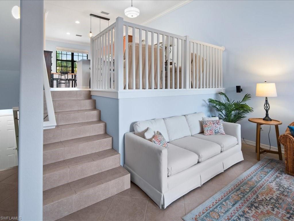 8985 Cambria Circle, Unit 215 Naples, FL 34113 - Photo 8 of 36 a living room with furniture and a chandelier
