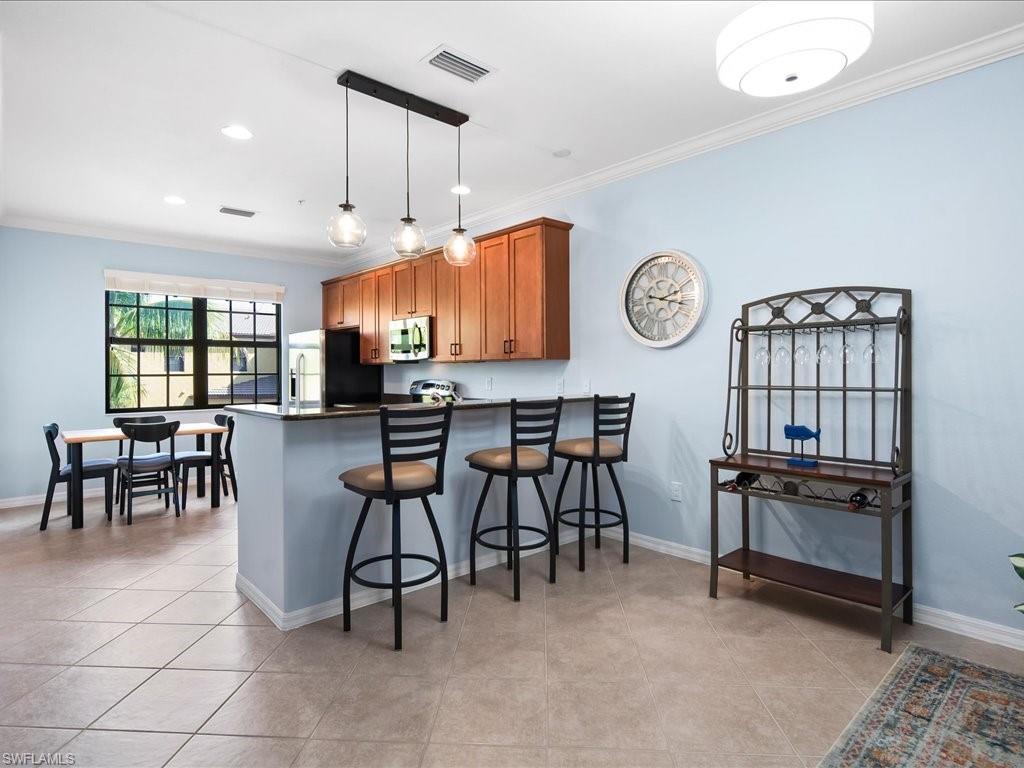 8985 Cambria Circle, Unit 215 Naples, FL 34113 - Photo 9 of 36 a view of dining table and chairs in a room