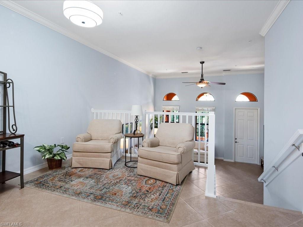 8985 Cambria Circle, Unit 215 Naples, FL 34113 - Photo 10 of 36 a living room with furniture and a chandelier