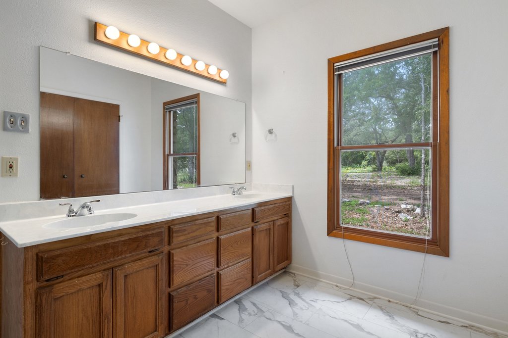 244 Woodway Elgin, TX 78621 - Photo 23 of 40 a bathroom with a double vanity sink and a mirror