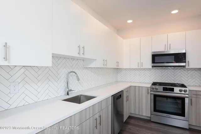 a kitchen with stainless steel appliances a sink a stove and cabinets