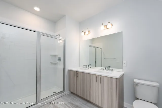 a bathroom with a double vanity sink mirror and toilet